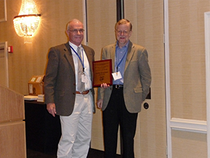 jan-breuckner1 Jan Brueckner (left) receiving a plaque from Vernon Henderson