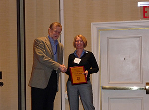 elena-irwin2 Elena Irwin (right) receiving a plaque from Vernon Henderson